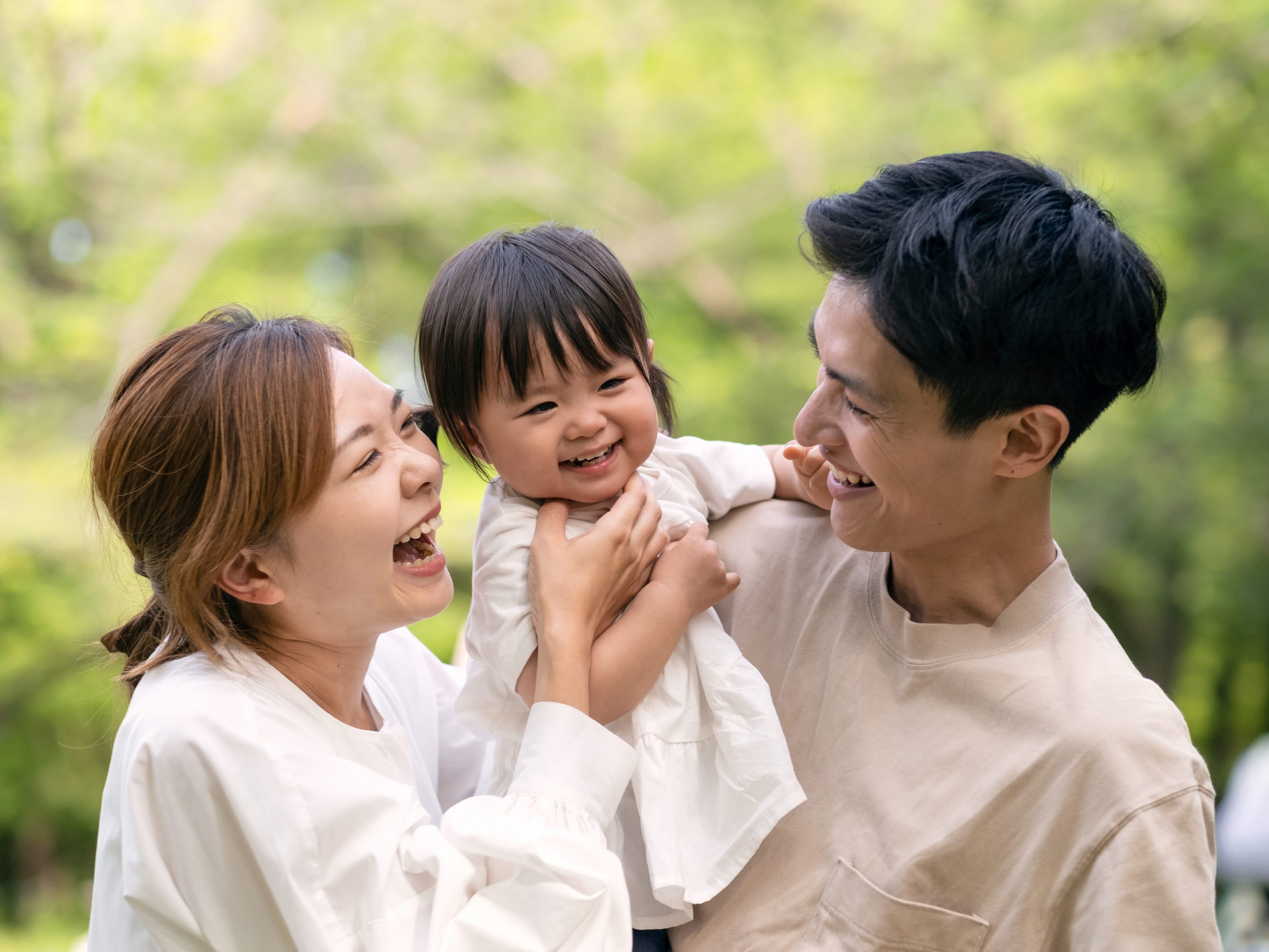 新緑の公園で微笑む家族のポートレート